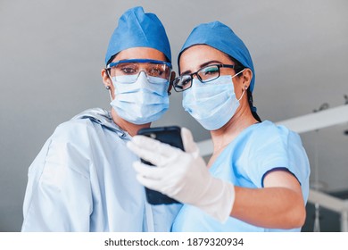 couple of latin women doctors taking a photo selfie with a smartphone in a Mexican hospital in Mexico or Latin America - Powered by Shutterstock