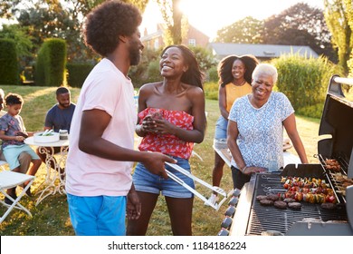 Couple laughing at a multi generation family barbecue - Powered by Shutterstock