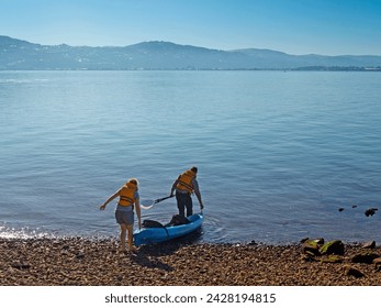 Couple launching kayak, matiu, somes island in wellington harbour, north island, new zealand, pacific - Powered by Shutterstock