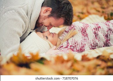 Couple Laying On Leafs In Park And Cuddling 