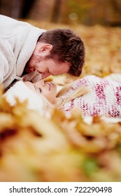     Couple Laying On Leafs In Park And Cuddling 