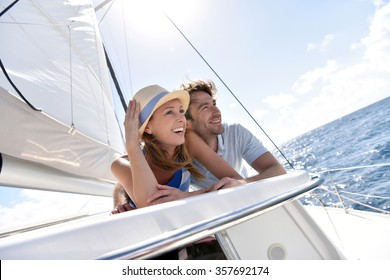 Couple laying on a sailboat deck during cruise