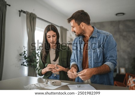 Couple learn and practice how to make a clay figurine, pottery