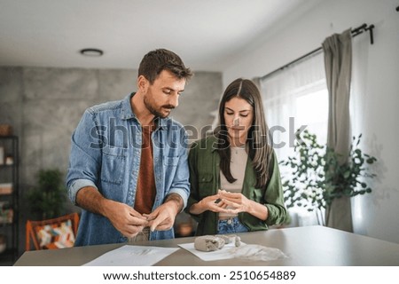 Couple learn and practice how to make a clay figurine, pottery