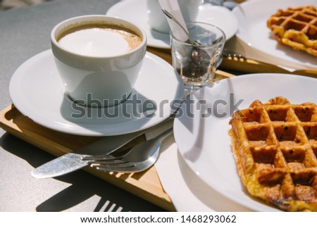A couple of Liege Waffles with 2 cups of cappuccino at a city Cafe in Ghent. 