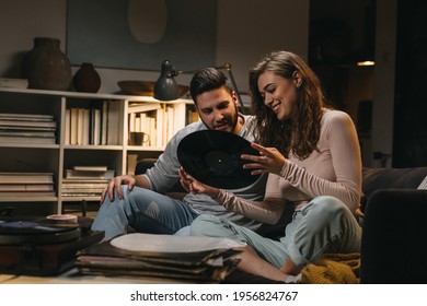 Couple Listening To A Music On Record Player At Home