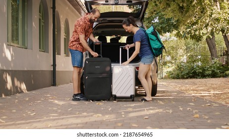 Couple Loading Vehicle Trunk With Luggage While Going On Marriage Anniversary Holiday Citybreak. Married People Loading Car With Baggage And Trolleys While Going On Summer Field Trip.