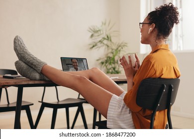 Couple in a long distance relationship doing a video call. Woman sitting at table holding cup of coffee talking with her boyfriend over a video call. - Powered by Shutterstock