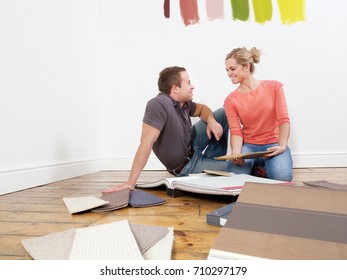 Couple Looking At Carpet Samples.