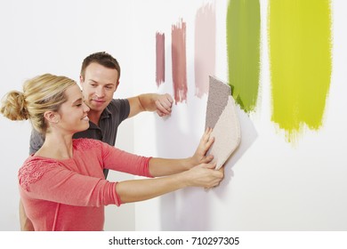 Couple Looking At Carpet Samples.