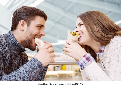 Couple Looking At Each Other While Eating Fast Food