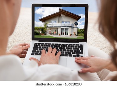 Couple Looking At House On Laptop's Screen