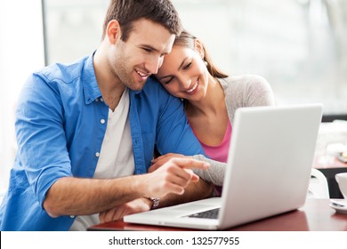 Couple looking at laptop - Powered by Shutterstock