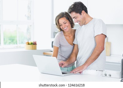 Couple Looking At Laptop In Kitchen