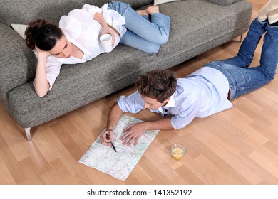 a couple looking a map at home - Powered by Shutterstock