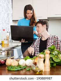 couple looking at notebook during cooking food at home kitchen