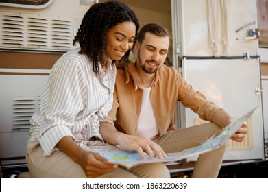 Couple Looking On Map Near Rv, Camping In Trailer