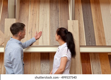 Couple Looking At Parquet Board For Home Flooring In Store, In Home Improvement Warehouse Exterior