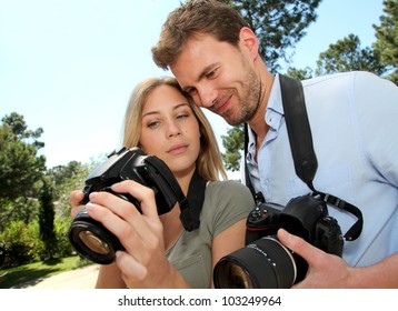 Couple looking at pictures through camera screen - Powered by Shutterstock