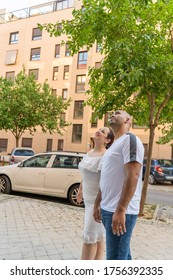 Couple Looking Up Saying Hi To Neighbors And Family