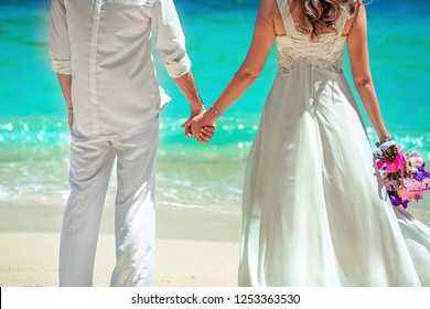 Couple looking at the sea in wedding clothing. Back view. Phuket. Thailand. Trip to warm destination.