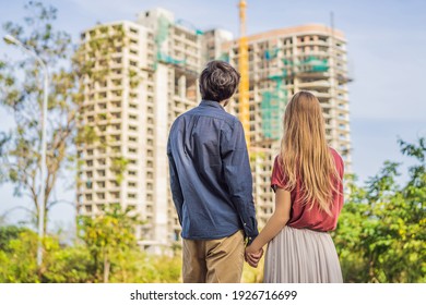 Couple looking at their new house under construction, planning future and dreaming. Young family dreaming about a new home. Real estate concept