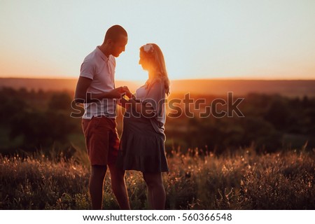 couple in love against the backdrop of a beautiful sunset. Pregnancy