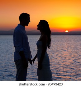 Couple In Love Back Light Silhouette At Lake Orange Sunset