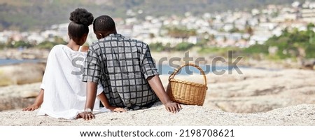 Couple, love and beach picnic for black woman or man on summer South Africa holiday near sea, water or ocean city. Safety, trust or security with zen people and view on nature rock on travel vacation