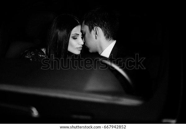 Couple in love in a black\
car
