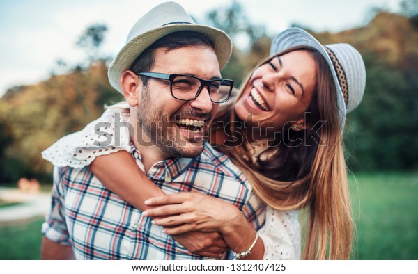 Couple in love. Boyfriend carrying his girlfriend on piggyback. Love and tenderness, dating, romance. Lifestyle concept
