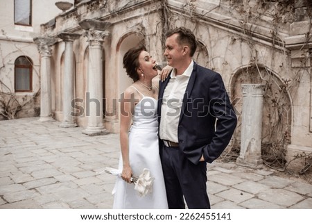 A couple in love,  The bride and groom are dressed in a wedding suit and dress, hugging, kissing ech other and posing together