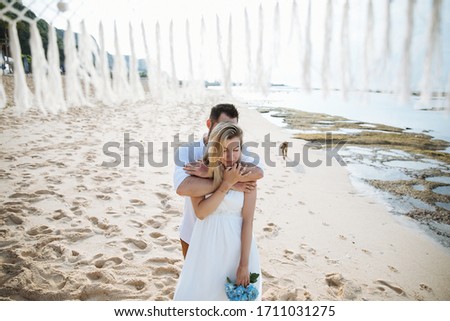 couple in love - the bride and groom on the wedding day hug and kiss on the beach by the ocean on the exotic Asian island of Bali in Indonesia, an incredible landscape 