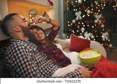 Couple in love at Christmas eve enjoy with popcorn while watching tv