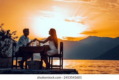 Couple in love drinking champagne wine on romantic dinner at sunset on the beach - Powered by Shutterstock