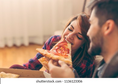 Couple in love eating pizza for lunch and having fun