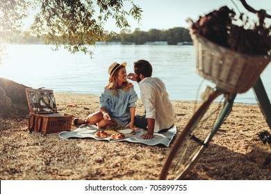 Couple in love enjoying picnic time and food outdoors. - Powered by Shutterstock