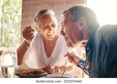 Couple, love and food with a senior man and woman on a date in a restaurant while eating on holiday. Travel, romance and dating with an elderly male and female pensioner enjoying a meal together - Powered by Shutterstock