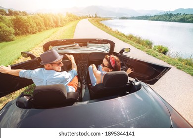 Couple in love getting into the convertible auto cabriolet and starting a trip. Couple honeymoon, traveling or vacation concept image.