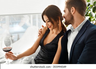 Couple In Love. Happy Romantic Smiling Elegant People Having Dinner, Drinking Wine, Celebrating Holiday, Anniversary Or Valentine's Day In Gourmet Restaurant. Romance, Relationships Concept.