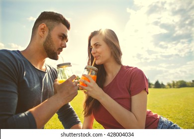 couple in love have fun in the park and drink smoothies and eating fruit at a picnic - Powered by Shutterstock