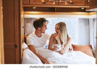 Couple In Love Having Fun Together In Bed In Morning, Young Man And Woman Newlyweds Hugging On Cozy Bed In Trailer Mobile Home Or Recreational Vehicle During Family Local Travel