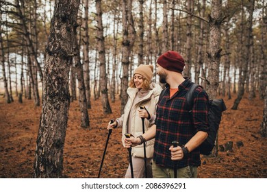 Couple In Love Hiking Together In A Pine Forest, Using Trekking Poles. Millennial Hipsters Travelers Spending Time Together.