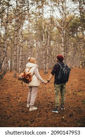 Couple In Love Hiking Together In A Pine Forest. Millennial Hipsters Travelers Spending Time Together.