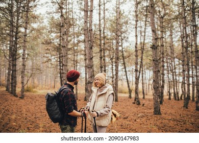 Couple In Love Hiking Together In A Pine Forest, Using Trekking Poles. Millennial Hipsters Travelers Spending Time Together.