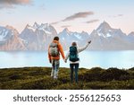 Couple in love hiking travel in Norway man and woman friends holding hands enjoying view, active vacations healthy lifestyle holidays tour outdoor family adventure mountaineering trip in Lyngen Alps