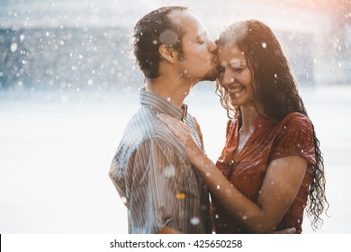 Couple In Love Hugging And Kissing Under Summer Rain