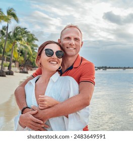 Couple in love hugging on the sandy exotic beach while they have a evening walk by the Trou-aux-Biches seashore on Mauritius island. People relationship and tropic honeymoon vacations concept image. - Powered by Shutterstock