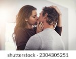 Couple, love and kissing in home for romantic bond, quality time and care together. Young man, woman and kiss for romance of lovers in happy relationship, intimate moment and passionate affection
