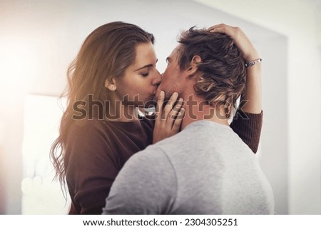 Couple, love and kissing in home for romantic bond, quality time and care together. Young man, woman and kiss for romance of lovers in happy relationship, intimate moment and passionate affection